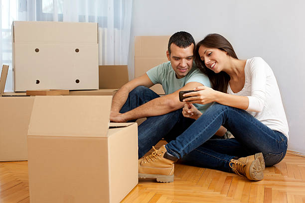 istock Couple Moving House relaxing with smart phone 185321420