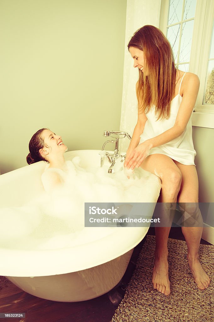 Młoda dziewczyna rozmawia z matką w trakcie kąpieli. - Zbiór zdjęć royalty-free (Łazienka)