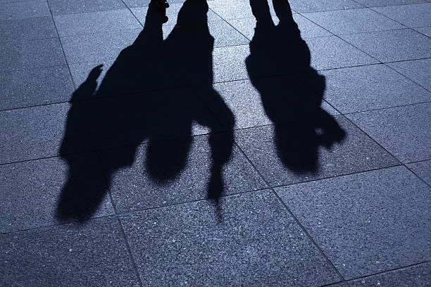 People threatening in blue night shadows stock photo