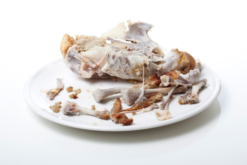 Roast chicken carcass on a plate isolated on white