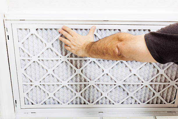 Replacing AC Filter Man replacing A/C filter for a home air conditioning system. filtration stock pictures, royalty-free photos & images