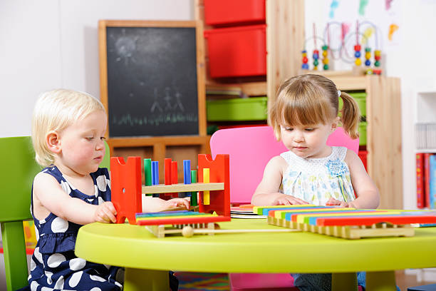 istock Toddler/ Pre-Schooler And Peer Playing With  Multi-coloured Toy At Nursery 185324571