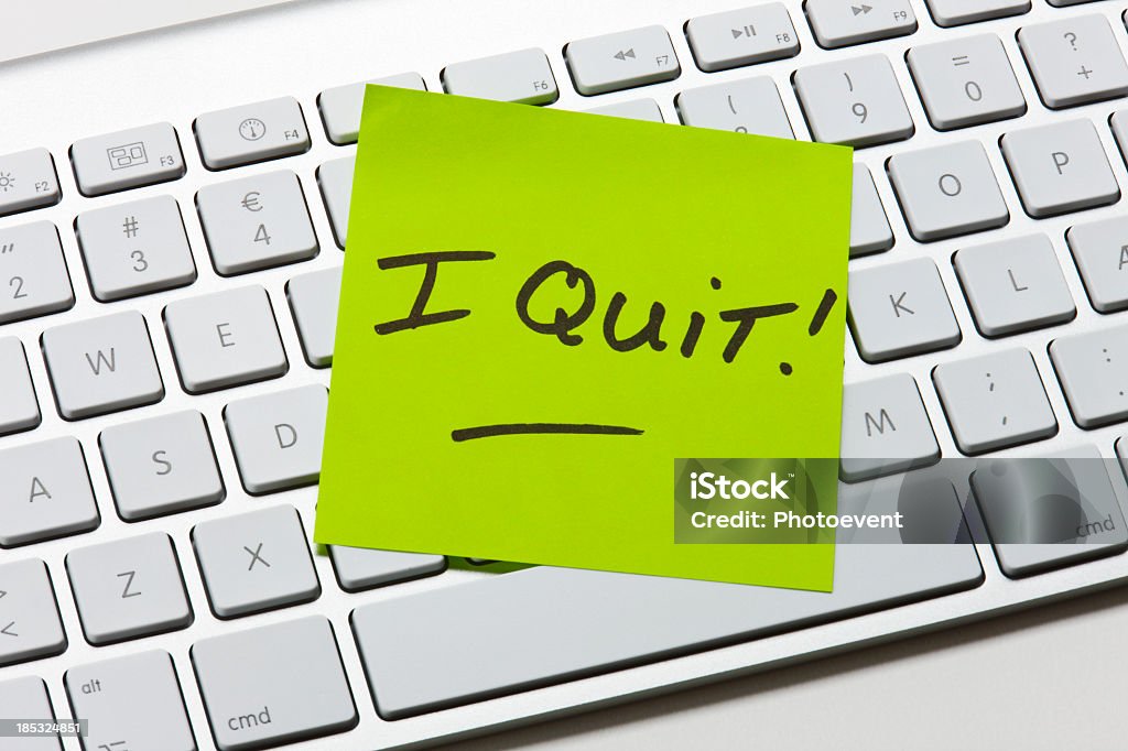 A green sticky note of resignation I Quit Note on keyboard Quitting a Job Stock Photo