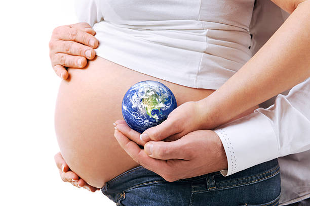 беременных пара, держа земли - human pregnancy earth globe mother стоковые фото и изображения