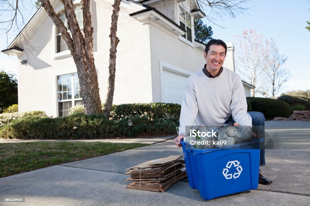 Man with recycling bin Asian/Caucasian man (40s) taking out recycling bin and cardboard. Men Stock Photo