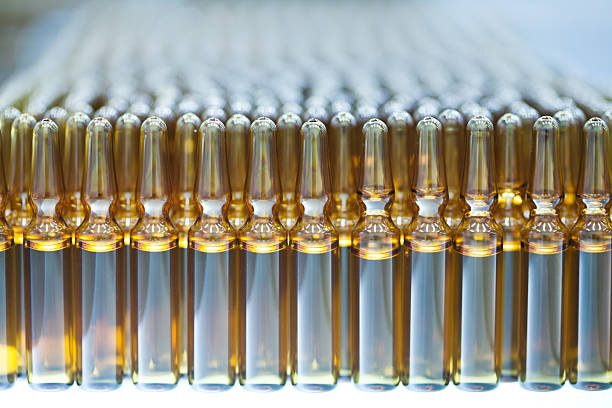 Pharmaceutical Equipment "Optical inspection, inspects vials and ampoules for particulates in liquid and container defects. Soft focus and Shallow DOF." ampoule photos stock pictures, royalty-free photos & images