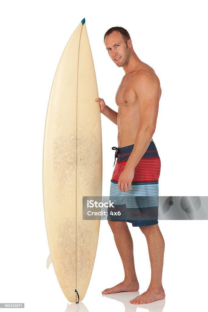 Hombre de pie con tabla de surf - Foto de stock de 30-39 años libre de derechos