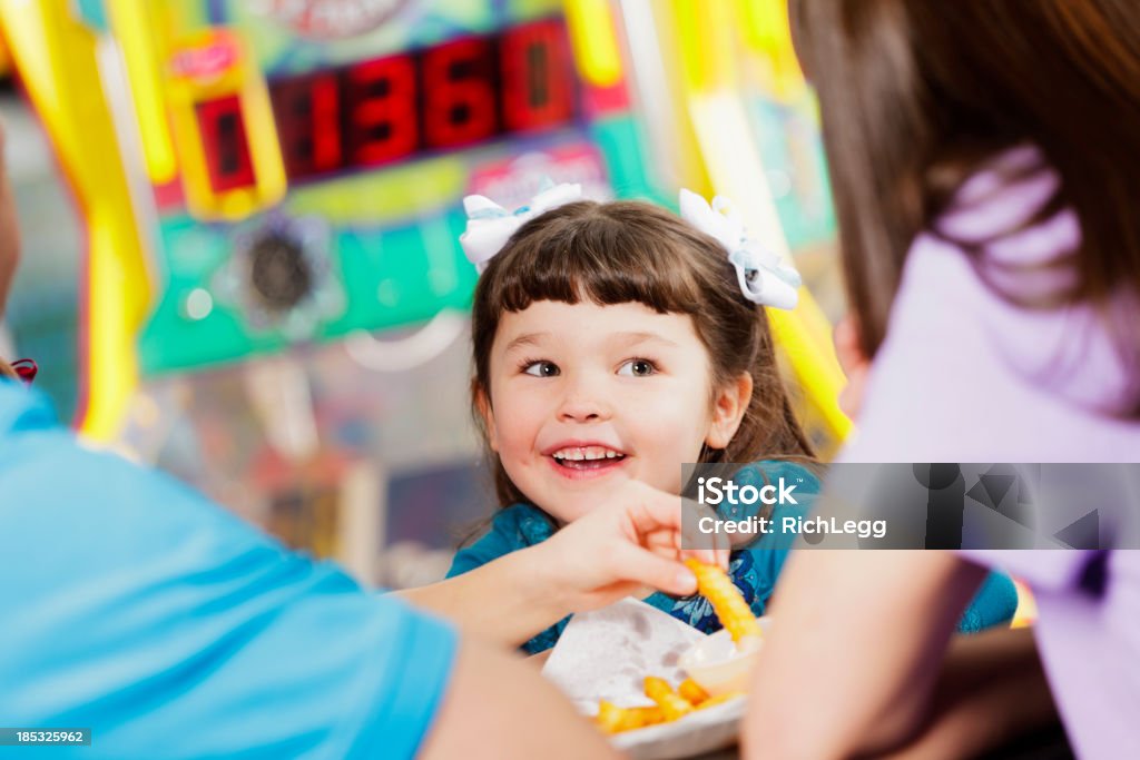 Happy Little Girl A happy little girl in an amusement arcade. Amusement Arcade Stock Photo