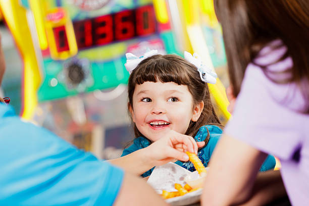 Happy Little Girl A happy little girl in an amusement arcade. arcade photos stock pictures, royalty-free photos & images