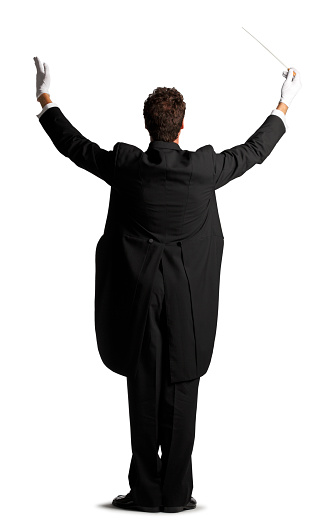 A rear view of a music conductor dressed in tails in the act of conducting.  Against a white backdrop there is room for copy space.  He stands in a formal position, arms raised and gloves on his hands.  He is ready to conduct an orchestra or symphony.  The conductor demands attention. 