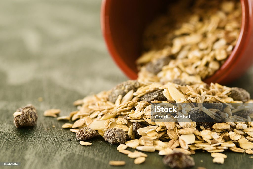 Oat meal cereal "Oat meal cereal mixed with raisin and almond slices on wood backgroundPlease see below light box for more Nuts, Lentils, and Grains image options:" Breakfast Stock Photo