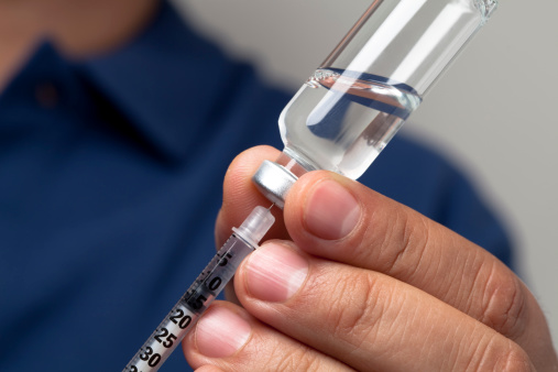 Male hands filling a syringe with the right dosage for an insulin shot.  You may also like: