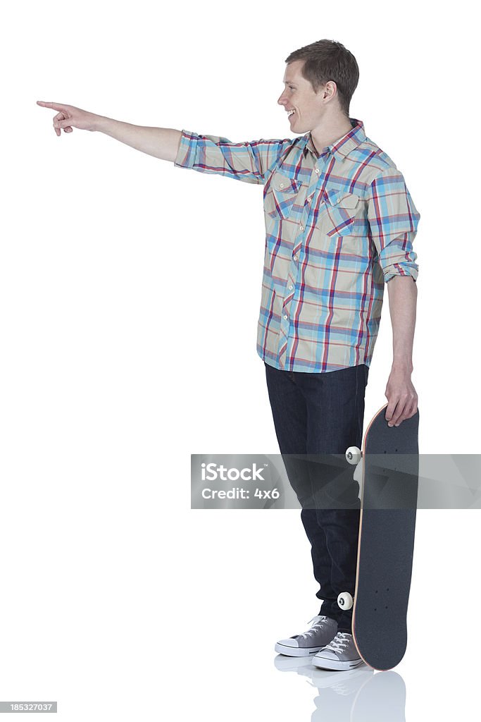 Homem de pé com skate e a apontar - Royalty-free Fundo Branco Foto de stock