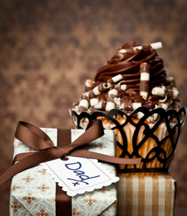 Gourmet cupcake and gift for Father's Day or birthday shot against textured background