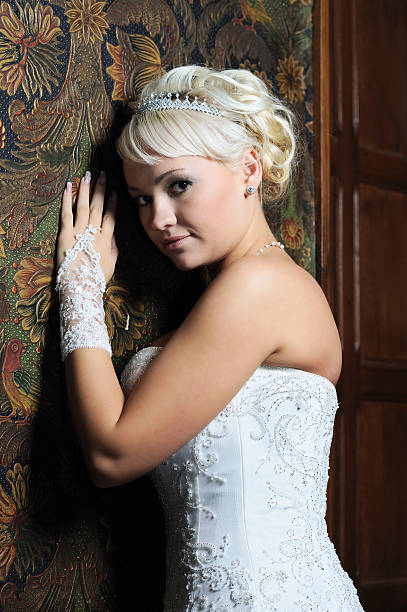 блондинка невеста в белое свадебное платье leaning в стене - glove formal glove white wedding стоковы�е фото и изображения