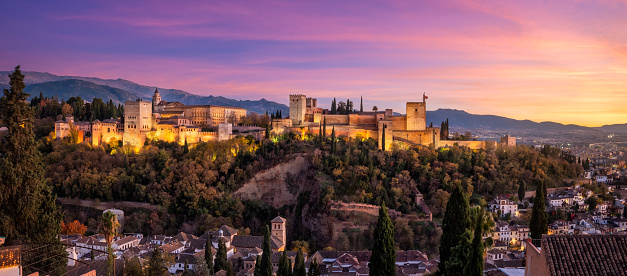 Panoramic view of The Alhambra in Granada at sunset with Sierra Nevada mountains in the Background. Andalusia, southern of Spain