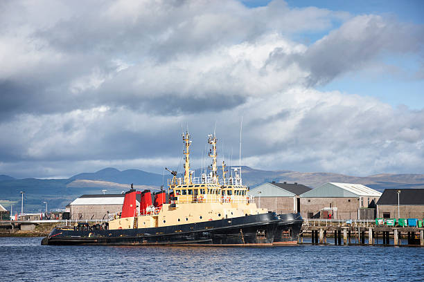 Tug Boats Docked At Greenock Two tug boats docked side-by-side in harbour at Greenock on the River Clyde west of Glasgow. clyde river stock pictures, royalty-free photos & images