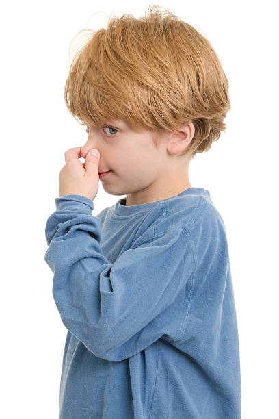 Little Boy Pinching Nose Portrait of a little boy on a white background. http://s3.amazonaws.com/drbimages/m/sc.jpg holding nose stock pictures, royalty-free photos & images