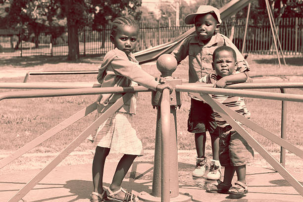 trois enfants sur la merry-go-round - carousel merry go round child african descent photos et images de collection