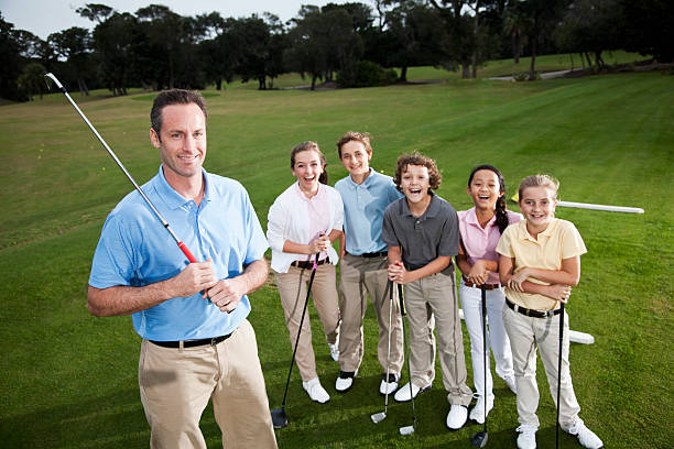 golf profesional con grupo de niños en el campo de práctica de golf - sc0529 fotografías e imágenes de stock