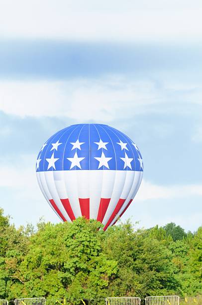 istock Patriotic hot air balloon behind trees with copy space above 185329798