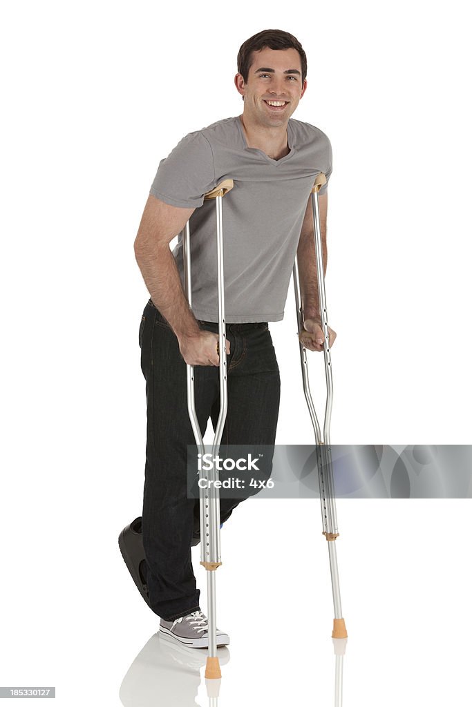 Ferido homem a caminhar com a ajuda de crutches - Royalty-free Fundo Branco Foto de stock