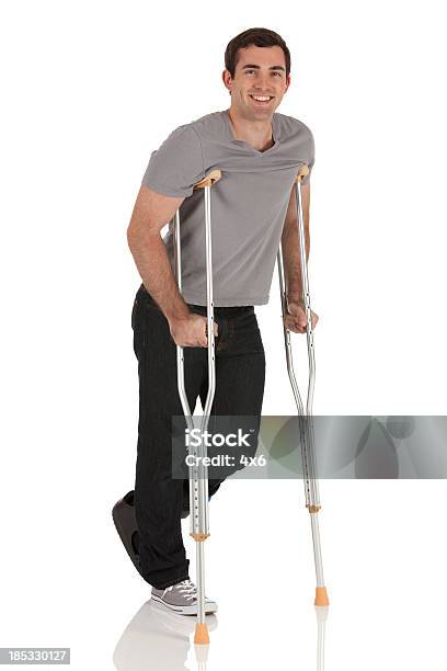 Ferido Homem A Caminhar Com A Ajuda De Crutches - Fotografias de stock e mais imagens de Fundo Branco - Fundo Branco, Homens, Muleta