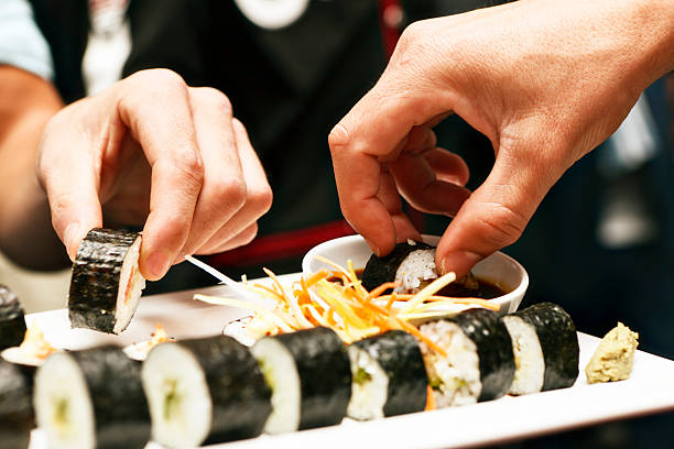 Mains partager un plateau de sushis au restaurant asiatique - Photo