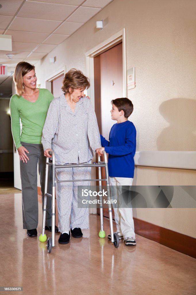 Famílias visitando idosos mulher em hospital - Foto de stock de Assistência royalty-free
