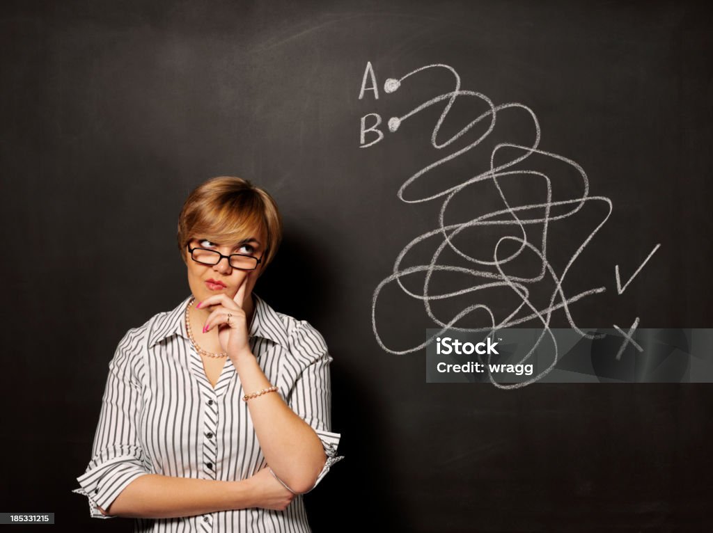 Puzzled about the Puzzle "Businesswomen/teacher/student with a puzzle on a blackboardClick on the links below to see more of my finance, education and stationery images." Letter B Stock Photo