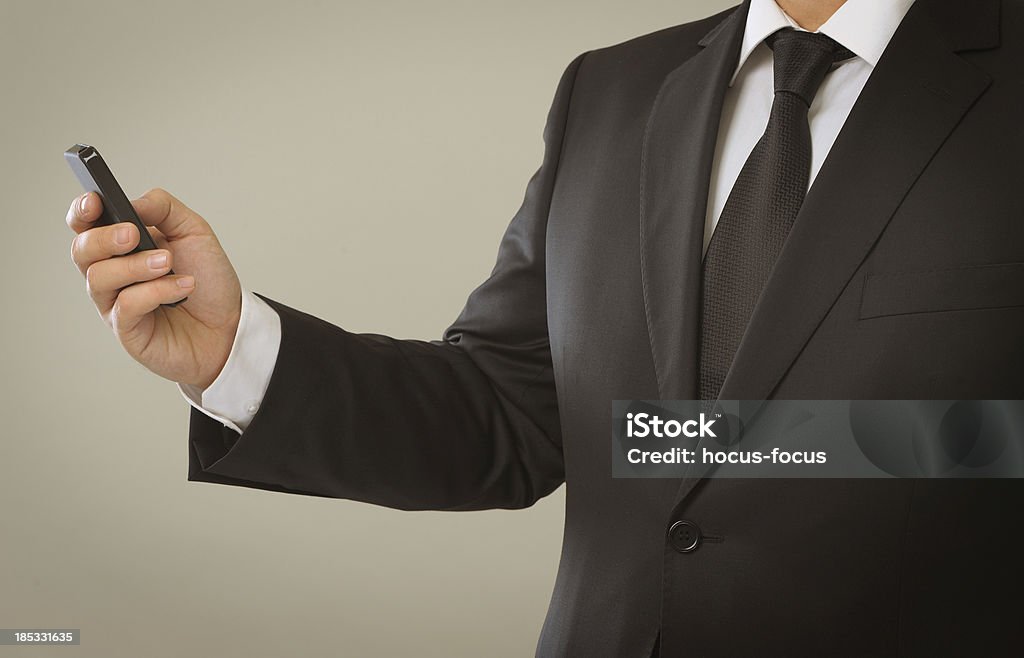 Businessman using smart phone "Businessman in black suit, using touch screen smart phone.Please see some similar pictures from my portfolio:" Adult Stock Photo