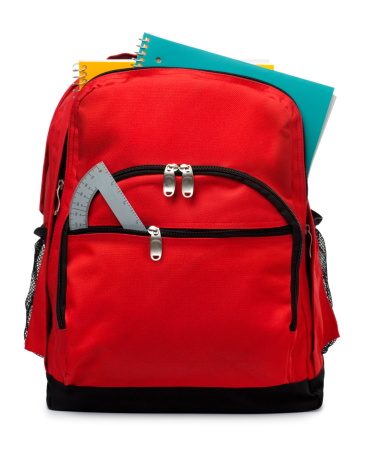 This is a photo of a red backpack with school supplies isolated on a white background.