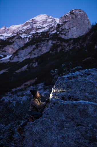 Determinate Woman Geologist Researching Minerals in Winter High Mountains at Dusk
