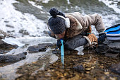 Survival Expert Drinking Water Through a Water Purifier