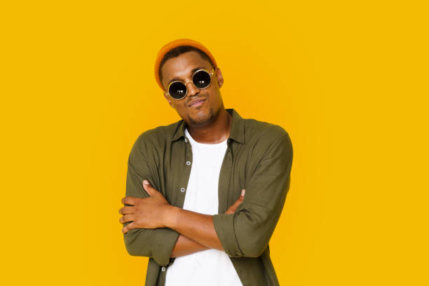 istock Confident Trendy Handsome Man 20s In Basic Closing With Crossed Hands. Young Expertise In Business Concept. Studio Shot Of Cool Clever Intelligent Executive Man Isolated Over Yellow Background. 1853423951