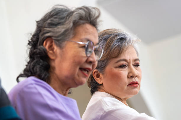 close up senior females and male sitting on bench. older people are listening and enjoy meeting focus group at living room. joyful carefree retired senior friends enjoying relaxation at nearly home. - senior adult human face male action imagens e fotografias de stock