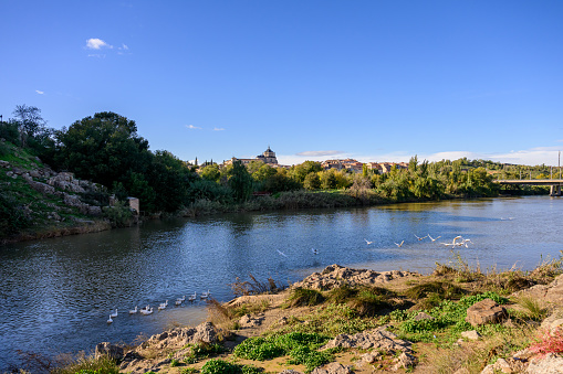 The Tagus River flows through the city of Toledo in central Spain. Toledo is situated on a hill overlooking the Tagus, providing picturesque views of the river and the surrounding landscape.