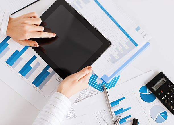 istock woman with tablet pc and chart papers 185365447