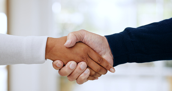 Handshake, agreement and closeup of business people in office for welcome to a new recruit or partnership. Zoom of professional female manager with shaking hands offer for deal, greeting or thank you