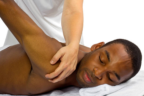 Young man receiving a back massage young female therapist helping young male patient chiropractic adjustment photos stock pictures, royalty-free photos & images