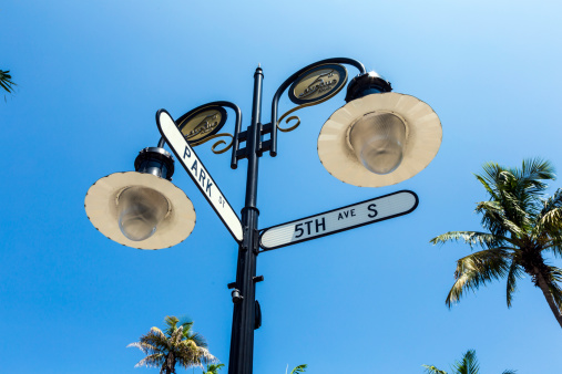 historical street sign in Naples, Florida under blue sky