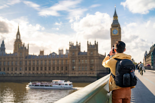 Unrecognizable young Latin man tourist against Big Ben and clock tower barrier in London