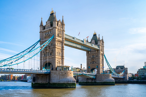 Tower bridge with flags over rippling river in London