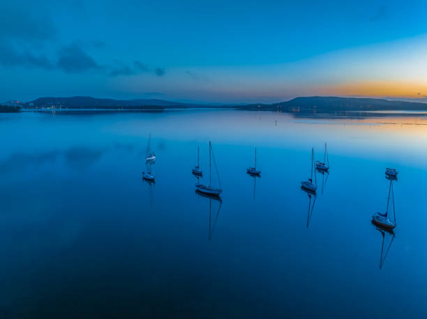 istock Aerial sunrise waterscape with boats, reflections and low cloud 1853849872