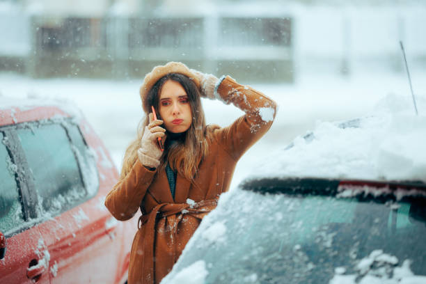 mujer llamando al servicio de automóviles después de una ventisca de nieve. - vehicle breakdown car stranded women fotografías e imágenes de stock