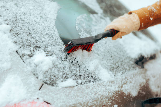 istock Person Wiping Snow from a Windshield with a Brush 1853945983