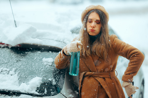 Stressed person having problems getting her car out during snowstorm
