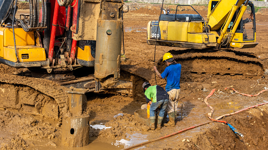 padang,Indonesia-11 October 2023:two construction workers are installing bore piles to dig foundation holes at the construction site