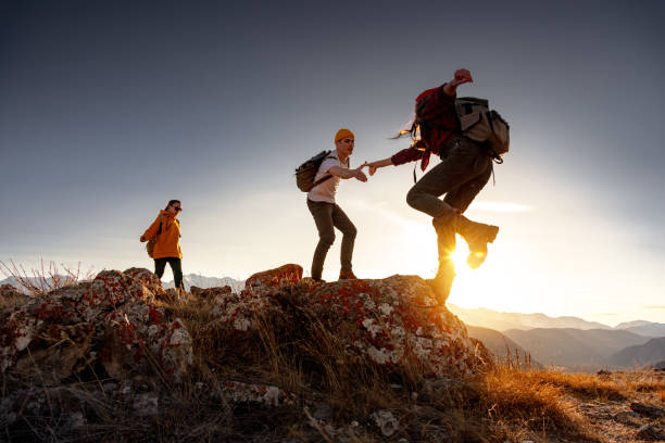istock Group of young hikers walk with backpacks at sunset 1854015251