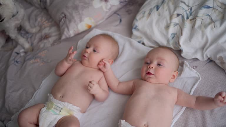 Twin baby brothers in bed in the morning